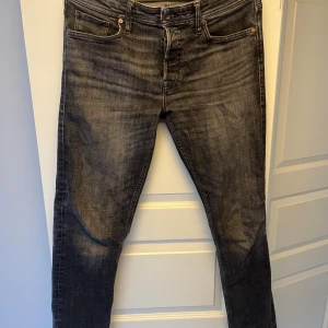 Svarta tapered jeans Jack & Jones - Snygga svarta jeans från Jack & Jones i modellen Tapered/Mike. Jeansen har en tvättad look med lätt slitning, klassiska fem fickor och smalare ben. Perfekta för dig som gillar en avslappnad men ändå stilren vibe. Minimalt slitage, storlek är 31/32 nypris: 899kr.