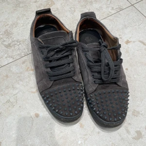 Christian Louboutin svarta sneakers med nitar - Byt sulor i skon annars väldigt bra pris kan diskuteras 