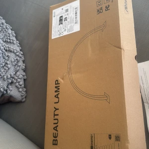 Beauty Lamp Half Moon - Snygg och modern Beauty Lamp i halvmåneform, perfekt för smink, naglar eller arbetsbelysning. Produkten är ny i originalförpackning med tillbehör och manual. Kartongen har en mindre skada men lampan är i nyskick och komplett med USB-kabel och monteringsdetaljer.