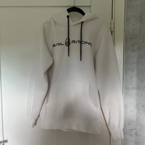 Vit Sail Racing Hoddie  - En vit Sail Racing hoddie. Det är bra skick på den och har använts litegrann men ändå bra. En snygg hoddie med snygg logga på bröstet. Storlek S på den men den känns som en XS på. Säljer denna på Vinted också. Hör av er om ni har frågor! 