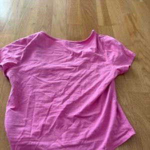 Rosa kortärmad topp från H&M Divided - En enkel och snygg rosa topp från H&M Divided. Modellen är kortärmad med rund halsringning och croppad passform. Tillverkad i mjuk bomull, perfekt för en chill och färgglad look.