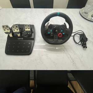 Logitech G29 Driving Force Racing Wheel - Logitech G29 ratt och pedaler för PlayStation och PC. Komplett med strömadapter, i mycket fint skick utan synligt slitage. Perfekt för realistisk racingupplevelse med force feedback, robusta metallpedaler och många knappar för full kontroll. Pris kan diskuteras vid snabb affär.