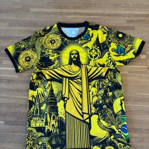 Brasil CBF x Nike gul fotbollströja M  | Kristusmotiv & unika detaljer - Säljer en unik Brasil CBF-fotbollströja från Nike, storlek M, i gult och svart med ett stort grafiskt tryck av Kristusstatyn, brasilianska flaggor och detaljerade illustrationer. Tröjan har broderat CBF-märke på bröstet och är tillverkad i lätt och ventilerande polyester – perfekt för match, träning eller streetwear.  ✔️ Lätt och andas ✔️ Kortärmad, regular fit ✔️ Aldrig använd  Storlek: M Skick: Ny / aldrig använd .