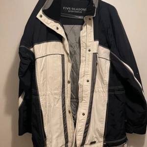 Svartvit vinterjacka från Five Seasons - Cool svart och vit vinterjacka från Five Seasons med sportig look. Jackan har dragkedja, knappar och flera fickor. Yttermaterial i nylon och foder samt fyllning i polyester. Perfekt för kalla dagar och har en avslappnad passform. Stl 40