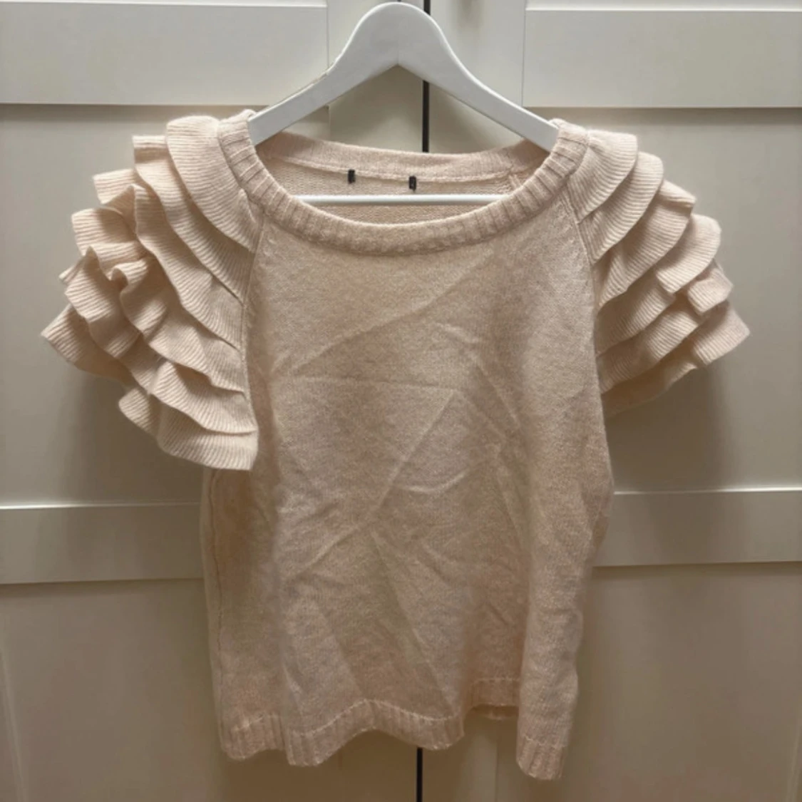 Beige stickad tröja med volangärmar