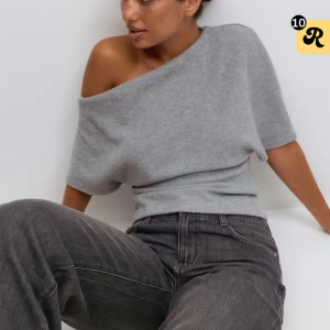 Grå offshoulder stickad tröja Gina Tricot - Säljer en helt oanvänd ljusgrå stickad tröja från Gina Tricot med offshoulder-design och korta ärmar. Tröjan har en tight passform i midjan. Perfekt för dig som gillar stilrena och trendiga plagg.