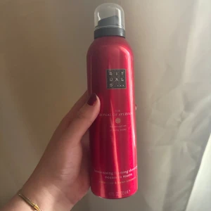 Rituals The Ritual of Ayurveda duschmousse - Röd metallicflaska med duschmousse från Rituals, serien The Ritual of Ayurveda. Doft av indisk ros och sötmandel. Flaskan har en praktisk pump och rymmer 200 ml. Perfekt för dig som vill ha en lyxig duschupplevelse.