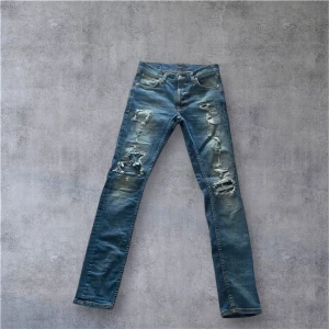 Nudie jeans med slitningar -  Ett par snygga nudie jeans med fina slitningar i modell lean dean,de finns även ett par synliga hål men de kan du få ihop av nudie gratis. Nypris 1500