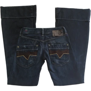 Vintage lowwaist flare/ bootcut jeans, Diesel  - Supercoola unika mörkblå utsvängda jeans från Diesel! Midjemått 68,5cm Grenhöjd 20cm Innerbenslängd 82,5cm Benslut (rakt över) 30,5cm, (OBS! Slutet på benöppningen är lite missfärgad på baksidan på båda ben, se bilder)