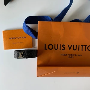 Svart armband  - Säljer ett svart armband men silver text där fram. Armbandet har diskret monogrammönster och exklusiv känsla, perfekt för dig som vill ha en ikonisk accessoar med lyxig touch.