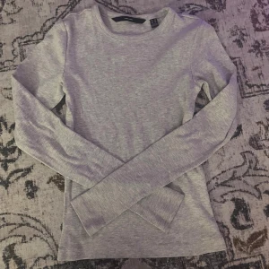 Långärmad tröja - Superskön ljusgrå långärmad tröja från Vero Moda i ribbad bomull. Enkel och stilren modell med rund halsringning, perfekt att matcha med jeans eller kjol. Sitter snyggt och är ett måste i basgarderoben.