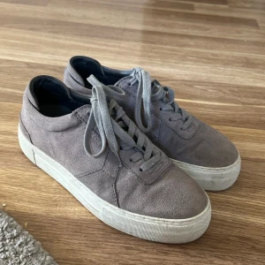 Grå mockasneakers från Axel Arigato - Snygga sneakers från Axel Arigato i använt skick som ni ser på bilderna!! Men fortriktigt snygga att bara ha till vardags! Hittar ingen storlek och jag kommer inte ihåg vilken storlek jag köpte dom i men eftersom att jag har 37 eller 38 och de är lite trånga så skulle jag säga att de passar bäst på 37😌