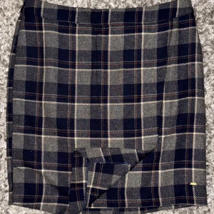 Klassisk rutig kjol – Hampton Republic - Klassisk rutig kjol – Hampton Republic Stilren och tidlös kjol i rutigt mönster från Hampton Republic. Perfekt för både vardag och kontor. Dragkedja bak med guldfärgad detalj.  📏 Mått: 	•	Midja: 40 cm 	•	Längd: 52 cm  🧵 Material: mjukt och stadigt tyg med fin passform. 🩶 Färg: grå, marinblå och beige rutor  🆕 ny skick!  💎hög kvalitet 