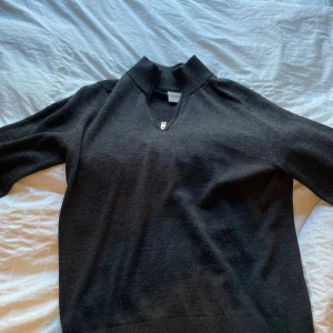 Svart half zip tröja Bruun & Stengade XL - Svart stickad tröja från Bruun & Stengade i storlek XL. Tröjan har en snygg half zip-dragkedja vid halsen och ribbade muddar. Perfekt för dig som gillar en stilren och enkel look med lite edge. Passar M (mer verklig storlek)