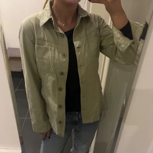 Mintgrön jacka hm  - Snygg mintgrön jacka från hm i bomull. Modellen har klassisk krage, två bröstfickor och knäppning framtill. Storlek 36, i mycket bra skick!