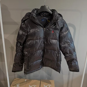 Glansig ralph lauren vinterjacka  -  Säljer nu en glans Ralph Lauren  jacka i nyskick. Tags finns kvar. Qr koden scannar till deras officiella hemsida. Storlek L men sitter som M. Han på bild är 185cm, 74kg. Pris kan diskuteras vid snabb affär!