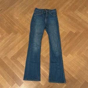 Blå bootcut jeans från Lee - Snygga blå jeans från L.O.G.G. med klassisk bootcut-modell. Jeansen har fem fickor, normal passform och är tillverkade i ett mjukt denimtyg. Perfekta för dig som gillar en tidlös look med lite utsvängda ben.