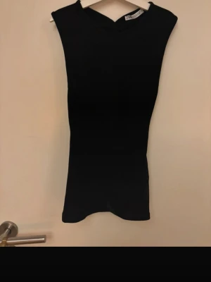 Svart ärmlös topp med öppen rygg från Zara - Säljer en svart, tight och ärmlös topp från Zara med en snygg öppen rygg. Perfekt festtopp