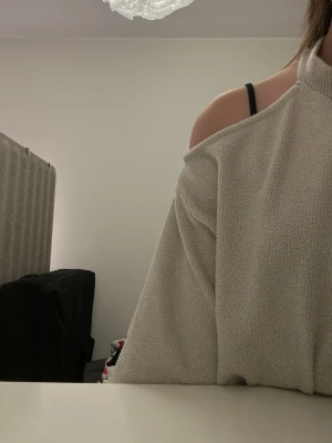 Beige offshoulder croppad tröja - Säljer en beige croppad tröja med offshoulder-design och hög krage. Tröjan är gjord i ett mjukt, strukturerat material som känns riktigt cozy. Perfekt för dig som vill ha en chill men ändå snygg vibe.💕✨😍