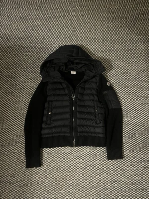 Moncler cardigan  - En svart moncler cardigan snygg och prutad eftersom jackan är perfekt förutom ett litet märke på armen men syns inte 