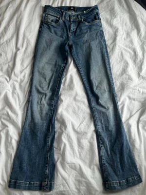 Blå bootcut jeans från LTB - Snygga blå jeans från LTB med bootcut-snitt och klassisk femficksdesign. Jeansen har en lätt tvättad look med kontrastsömmar och normal passform. Perfekta för dig som gillar en avslappnad stil med lite extra vidd vid bensluten.