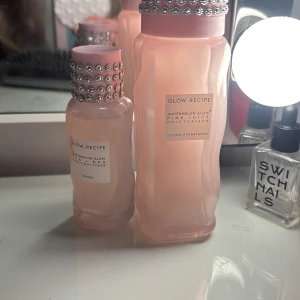 Glow Recipe Watermelon Glow duo - Glow Recipe Watermelon Glow Pink Juice Moisturizer och Watermelon Glow PHA+BHA Pore-Tight Toner. Båda kommer i snygga rosa flaskor med vågig design och dekorativa strassdetaljer på korken. Perfekt för dig som vill ha glow och fräsch hy med en lyxig känsla.