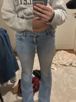 Lowwaist bootcut jeans - Storleken är konstig men det motsvarar M/ W28 . Säljer ett par ljusblå jeans med bootcut-modell och låg midja. Jeansen har klassisk femficksdesign, dragkedja och knapp framtill. Materialet är jeans och passformen är normal med lite utsvängda ben. Perfekta för en avslappnad och trendig look.