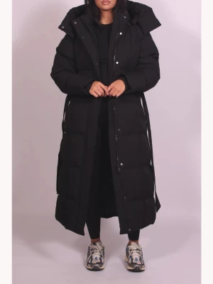 Svart lång pufferjacka med huva - Säljer en lång och varm pufferjacka med stor huva och bälte i midjan. dragkedja och knappar framtill. Perfekt för kalla dagar och har en riktigt chill oversized vibe. Oanvänd. Storlek xs men passar nog alla från xs till medium. Köpt för 1000kr