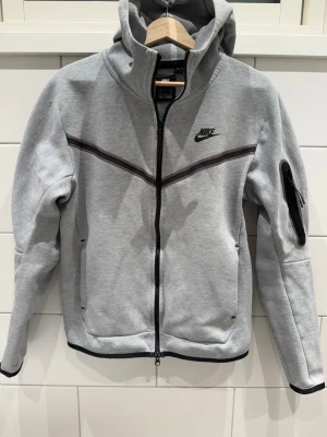 Nike Tech Hoodie  - Snygg hoodie i mycket bra skick undantaget en liten slitning på ena axeln samt hängaren (se bild). Storlek S. 