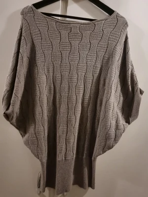 Glittrig stickad tröja från D&K Mode - Säljer en beige stickad tröja från D&K Mode i storlek S/M. Tröjan har ett glittrigt garn, bred ribbad kant nertill och ett snyggt strukturerat mönster. Modellen är loose fit med trekvartsärmar och passar perfekt till höst och vinter.