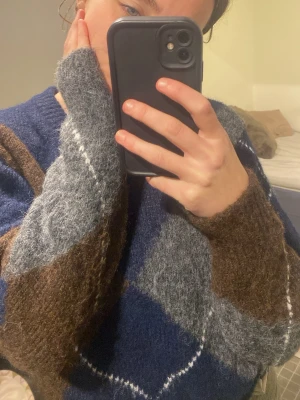 Mysig stickad tröja från Gina Tricot - Säljer en stickad tröja från Gina Tricot i storlek S. Tröjan har ett rutigt mönster i marinblått, grått och brunt. Den är långärmad och har en loose fit, perfekt för kyliga dagar. Supermjuk och skön att ha på sig!