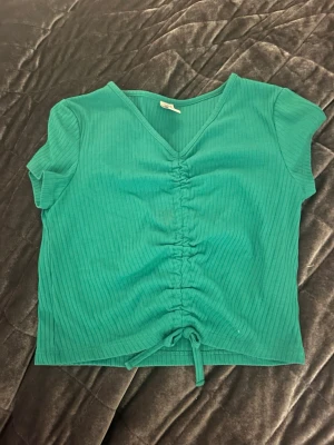 Grön ribbad topp från Lindex - Snygg grön ribbad topp från Lindex i storlek 146-152 med korta ärmar och v-ringning. Tröjan är i gott skick och Ordinarie pris var 189kr. Pris kan diskuteras vid snabb affär. Funderingar? Skriv till mig💕