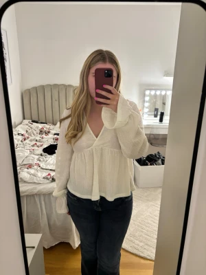 Vit blus - Snygg vit blus från gina med volang längst ner på ärmarna. Fin till både vardags och till fest! 