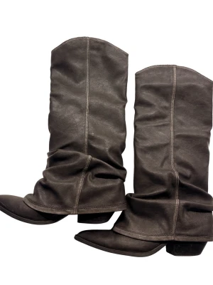 Svarta cowboy boots med spetsig tå - Säljer ett par bruna cowboy boots med spetsig tå och låg klack. Bootsens material är skinn och de har en slouchy, avslappnad form med markerade sömmar längs skaftet. Perfekt för dig som vill ha en cool westernstil.