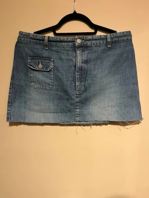 Blå jeanskjol från Marc O'Polo - Säljer en blå jeanskjol från Marc O'Polo i storlek L. Jag skulle säga att modellen är rak och midwaist, men att den även går att ha lågmidjat. Kjolen är avklippt längst ner. 