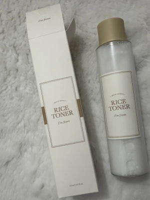 I'm From Rice Toner 150ml - Fräsch ansiktstoner med risextrakt från I'm From, levereras i en stilren transparent flaska med beige lock och matchande vit kartong. Perfekt för att återfukta och ge glow till huden. Innehåller 150ml.