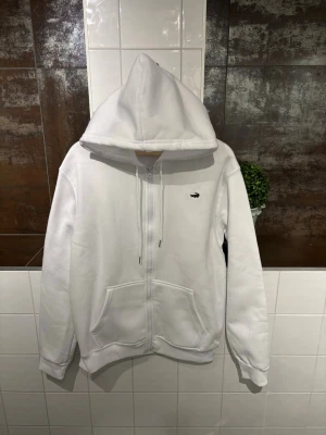 Lacoste zip up hoodie - Ny oanvänd hel vit Lacoste zip up. 