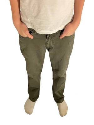 Olivgröna byxor från Ralph Lauren - Säljer ett par olivgröna byxor från Ralph Lauren med röd RL-brodyr på fickan. Byxorna har raka ben, normal passform och klassiska fickor både fram och bak. Perfekta för dig som gillar en clean och avslappnad look.