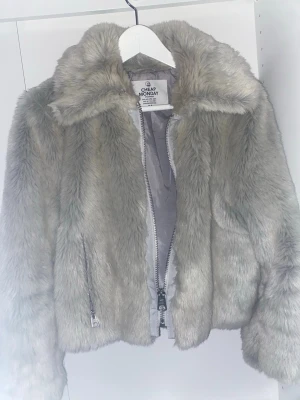 Beige pälsjacka från Cheap Monday - Säljer en fluffig och snygg beige pälsjacka från Cheap Monday i storlek M. Jackan har en bred krage, dragkedja framtill och två fickor med dragkedja. Perfekt för dig som vill ha en cool och varm look under höst och vinter.