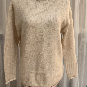 Beige stickad polotröja - Säljer en beige stickad polotröja med ribbad hög krage och långa ärmar. Tröjan har en enkel och clean design med mjukt material som känns skönt mot huden. Storleken är xs men passar även s