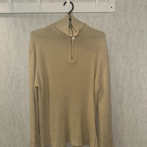Beige ribbad tröja med half zip - Beige ribbstickad tröja med hög krage och half zip-dragkedja framtill. Väldigt fint  skick . Storlek S