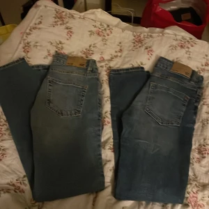 Blå jeans Skippy storlek 150 - Säljer ett par klassiska blå jeans från Skippy i storlek 150. Jeansen har en rak passform med fem fickor och snygga slitningar på benen. Perfekt för dig som gillar en enkel och tidlös denimlook.Det är 2 olika jeans modell slim och skippy.Paketpris.