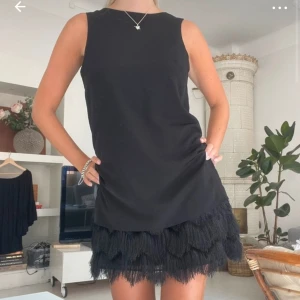 Svart ärmlös klänning med fransar - Så snygg och unik klänning! A-linje passform med fransar runt höfterna vilket ger en smickrande siluett. Verkligen så cool och går att ha till många olika tillfällen. Första bilden är lånad och resten är mina, skärp ingår inte, längd ca 90cm🌟