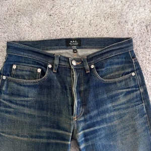 Selvedge APC jeans - Säljer ett par A.P.C. New Standard jeans i mörkblå selvedge. Riktigt snygg naturlig fade. Storleken är W28. Den har några små fläckar men  inget man tänker på. Måtten är: Midjebredd 38 cm, total längd 100 cm och benöppningen 18 cm.
