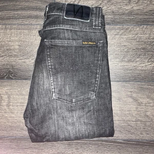 Nudie jeans  - Snygga svarta jeans från Nudie Jeans med skinny passform och klassisk femficksdesign. Midja 32cm, längd 109cm. Modell High Kai. JAG SKICKAR EJ FLER BILDER NÄR JAG BÄR JEANSEN! för storleksguide hänvisar jag till måtten och för bättre inblick i passformen rekommenderar jag att googla på modellnamnet. Jeansen kan vara uppsydda utan att jag noterat det så kolla måtten noggrant :) s3