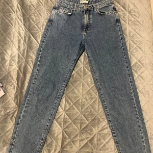 Blå Gina Tricot Perfect Jeans, strl 36 - Snygga blå jeans från Gina Tricot, modellen Perfect Jeans. Klassisk femficksdesign, raka ben och hög midja. Jeansen har en cool vintageblå tvätt och är tillverkade i slitstarkt bomullsjeansmaterial. Perfekt för dig som gillar en clean och tidlös look.