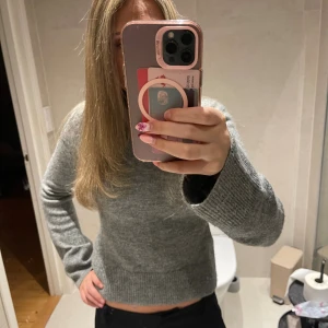 Grå stickad tröja - Jätte fin mörkgrå stickad tröja från H&M. Figursydd vid midjan och utsvänga ärmar🩷