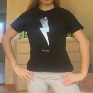 Zadig tshirt blixt - Snygg Zadig tshirt med blixt. Köpt på Plick. Färgen på blixten är lite sliten. Därav priset. Storlek 10, 138cm men passar större. Jag på bilden är 155cm xxs/xs