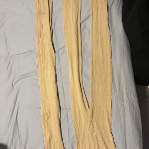 Beige tunna strumpbyxor - Säljer två par tunna, beige strumpbyxor med klassisk design. Perfekta för att ge benen en jämn ton och passar till många olika outfits. Materialet är mjukt och följsamt, vilket gör dem bekväma att bära hela dagen. Köpte ett 3-pack när jag bara behövde en, säljer de resterande 2. Köpte 3stycken för 300.