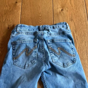 Ljusblå bootcut jeans med slitningar - Säljer ett par jeans från Nelly. Supersnygga! Säljer pga att dem ej kommer till användning. Är lite slitna vid fötterna, värt att ha i åtanke! ❤️pris kan diskuteras